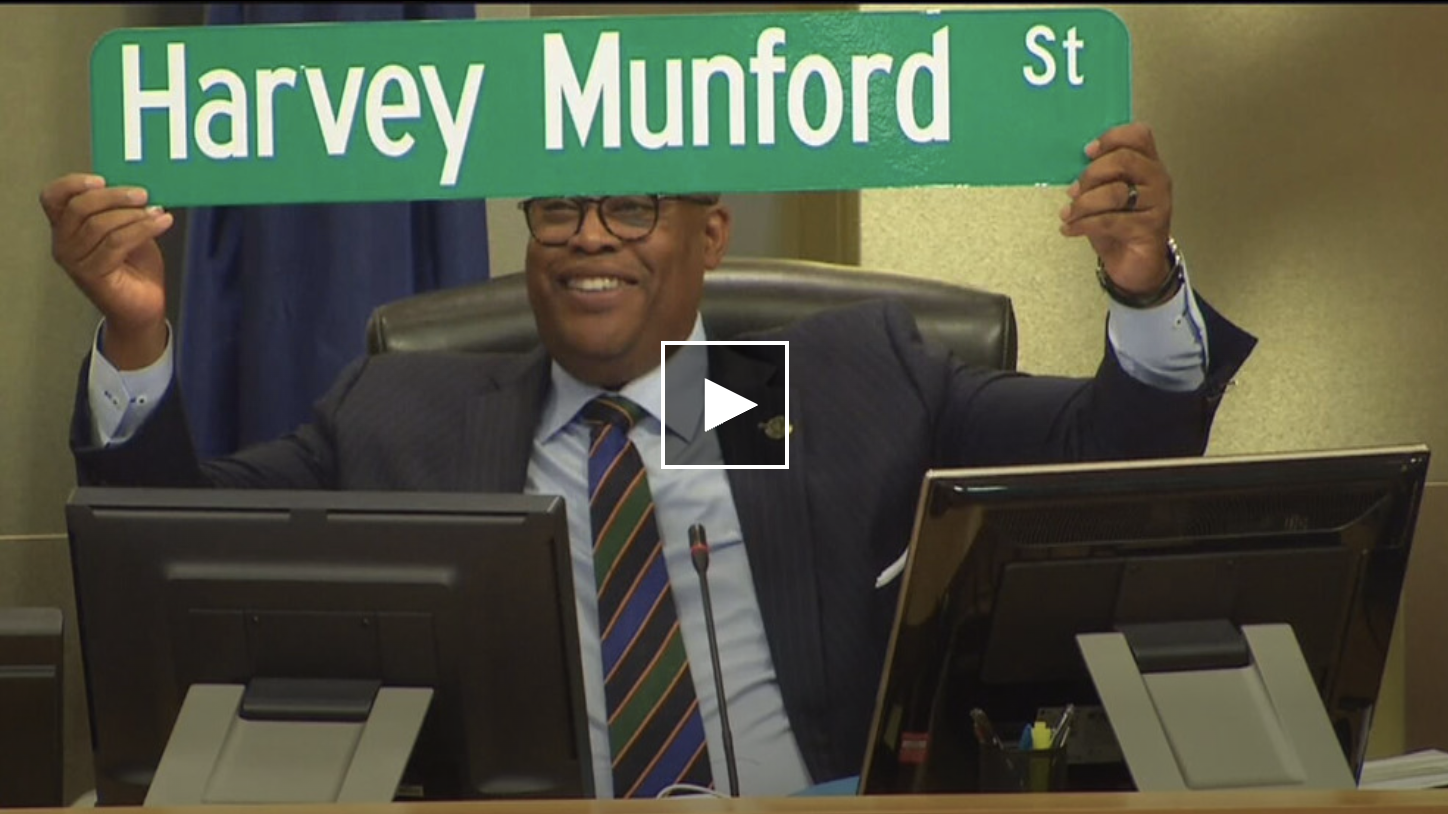 Photo of Cedric Crear holding the Harvey Munford street sign