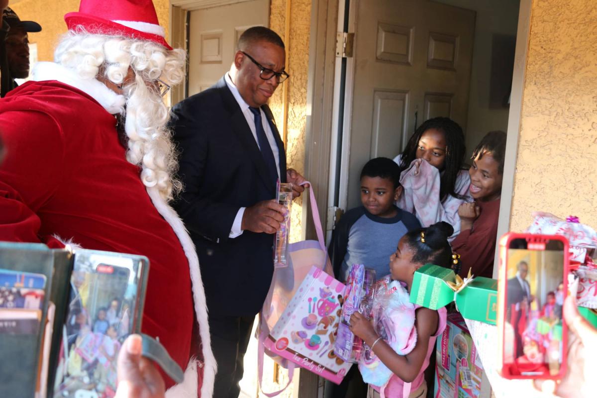 Ward 5 City Councilman Cedric Crear assists Thump Claus with Barbies, clothes and other fun toys.